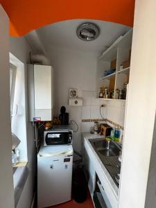 a small kitchen with a sink and an orange ceiling at ZLM Ultra Central Room in Târgu-Mureş