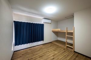 a room with a bed and a blue curtain at Oyado Yadokari - Vacation STAY 92325v in Anan