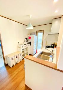 a kitchen with a sink and a white refrigerator at ABURATSUBO BEKKAN - Vacation STAY 17571 in Miura