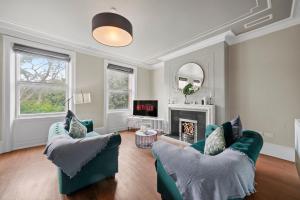 sala de estar con 2 sillas verdes y chimenea en Georgian Apartment In Yorkshire - Parking, en Wakefield 13 fotos más