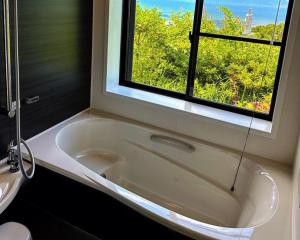 a bath tub in a bathroom with a window at Sky Sauna Kukai - Vacation STAY 97168v in Kumamoto +11 photos