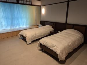 大津市にあるguesthouseKinari - Vacation STAY 99387vのベッド2台と窓のある寝室