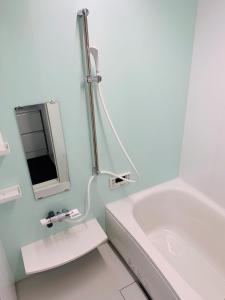 a white bathroom with a tub and a mirror at Quayside Sakuragicho 401 - Vacation STAY 17681 in Yokohama