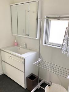 a white bathroom with a sink and a mirror at Quayside Sakuragicho 401 - Vacation STAY 17681 in Yokohama