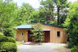 a small wooden building with a tree in front of it at Guesthouse Nagomi in Minamiaso - Vacation STAY 17895 in Minami Aso