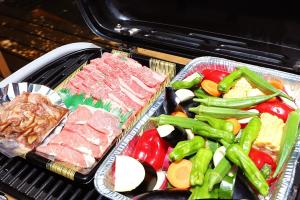 two trays of meat and vegetables on a grill at Guesthouse Nagomi in Minamiaso - Vacation STAY 17895 in Minami Aso