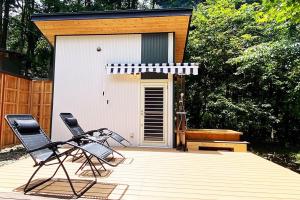 two chairs sitting on a deck in front of a shed at Guesthouse Nagomi in Minamiaso - Vacation STAY 17895 in Minami Aso