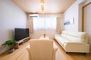 a living room with a white couch and a tv at BLUESOLARE Reef - Vacation STAY 14140v in Miyako Island