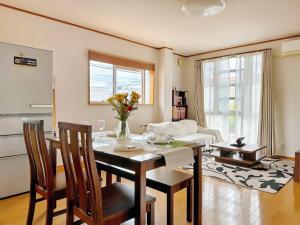 ein Esszimmer mit Tisch und Stühlen und ein Wohnzimmer in der Unterkunft Wanoie - Vacation STAY 17705 in Osaka