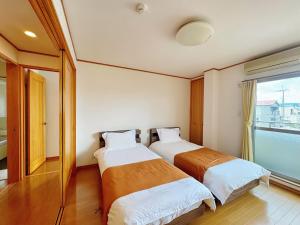 zwei Betten in einem Zimmer mit Fenster in der Unterkunft Wanoie - Vacation STAY 17705 in Osaka