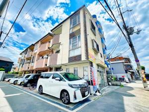 ein weißes Auto, das vor einem Gebäude geparkt ist in der Unterkunft Wanoie - Vacation STAY 17705 in Osaka