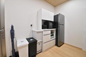 a kitchen with a black refrigerator and white cabinets at BLUESOLARE Reef - Vacation STAY 14140v in Miyako Island