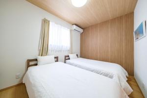 two beds in a small room with a window at BLUESOLARE Reef - Vacation STAY 14140v in Miyako Island