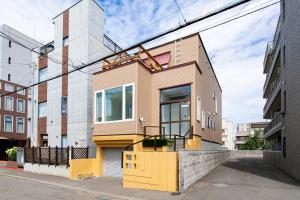 a small house with a yellow door on a street at S9W13 LABOINN - Vacation STAY 06250v in Sapporo