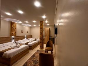 a hotel room with three beds and a chair at Pyramids Holiday Escape in Cairo