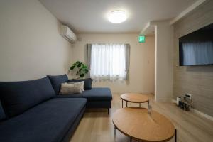a living room with a blue couch and a table at Flex cella satozuka - Vacation STAY 17763 in Sapporo