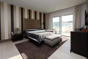 a bedroom with a bed and a chair and a window at Luxurious Penthouse in Marbella +34 photos