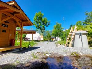 a house with a pond next to a wooden structure at Hakuba Mori no Wasabi Farm Auto Campsite - Vacation STAY 22257v in Hakuba