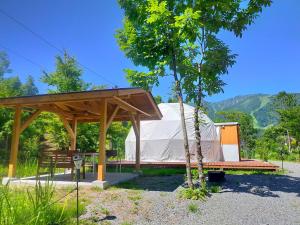 a tent with a picnic table and a tree at Hakuba Mori no Wasabi Farm Auto Campsite - Vacation STAY 22257v in Hakuba
