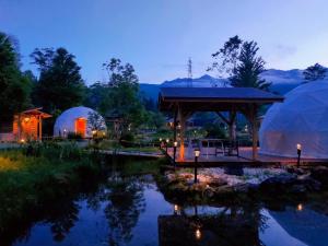 a lit up garden with domes and a pond at Hakuba Mori no Wasabi Farm Auto Campsite - Vacation STAY 22254v in Hakuba