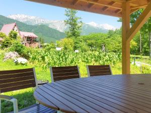 a table and chairs on a porch with a view of mountains at Hakuba Mori no Wasabi Farm Auto Campsite - Vacation STAY 22254v in Hakuba