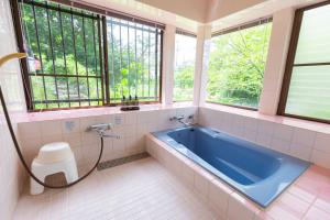 a bathroom with a blue tub and windows at Gracia Shuzenji - Vacation STAY 28497v in Izu +23 photos
