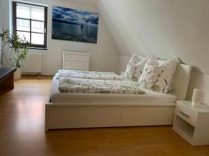 a bedroom with a bed with white sheets and pillows at Fewo Wanda in Wurzen