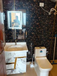 a bathroom with a sink and a toilet at Kanatal Majestic Resort by RIHS in Kanatal