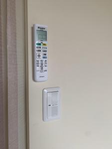 eine Fernbedienung an der Wand eines Zimmers in der Unterkunft Ieka Village Kiyosasawa - Vacation STAY 71845v in Sadamitsu + 5 Fotos