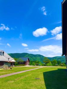 a green field with a house and mountains in the background at Makino MeguRia - Vacation STAY 32791v in Takashima