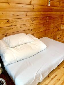 an empty bed in a room with wooden walls at Makino MeguRia - Vacation STAY 32791v in Takashima