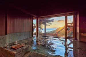 Cette chambre dispose d'une piscine d'eau et d'une grande fenêtre. dans l'établissement Private Resort Minamikaze - Vacation STAY 15105v, à Okawa