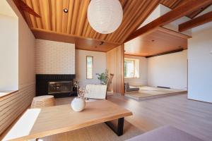 Elle comprend un salon doté d'une cheminée et d'un plafond en bois. dans l'établissement Private Resort Minamikaze - Vacation STAY 15105v, à Okawa