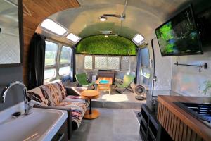 - un salon avec un canapé et une télévision dans une caravane dans l'établissement BAYBERRY×airstream - Vacation STAY 34826v, à Izumi