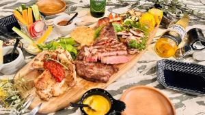 une table sur laquelle est posée une planche à découper remplie de nourriture dans l'établissement BAYBERRY×airstream - Vacation STAY 34826v, à Izumi