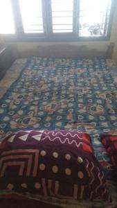 a bed with a colorful quilt on top of it at Krishna sadana beach side home stay in Hangārkatta