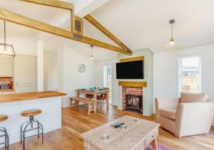 Sanctuary Caledonia Hot tub lodge في حصن أوغسطس: غرفة معيشة بها أريكة وطاولة