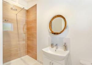 Sanctuary Caledonia Hot tub lodge في حصن أوغسطس: حمام مع حوض ودش مع مرآة