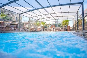 an indoor swimming pool with a large glass building at Hotel zur Pfalz in Kandel