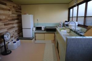 a small kitchen with a refrigerator and a sink at Nagomiso - Vacation STAY 42780v in Tsu +12 photos