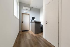 a hallway with white walls and a door and a counter at Mezzaluna Luxury Rooms by BarbarHouse in Mesagne