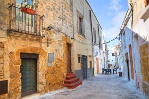 an alley in an old building with a table and chairs at Mezzaluna Luxury Rooms by BarbarHouse in Mesagne