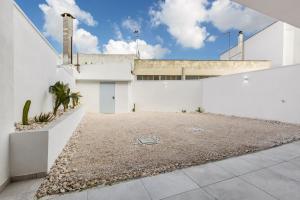 a white building with a large yard in front of it at Mezzaluna Luxury Rooms by BarbarHouse in Mesagne
