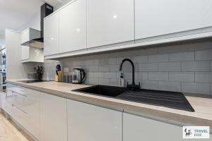 a kitchen with white cabinets and a sink at Anna's Central Stay in Nottingham +45 photos