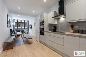 a kitchen with white cabinets and a table in it at Anna's Central Stay in Nottingham