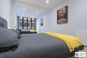 a bedroom with a bed with a yellow blanket on it at Anna's Central Stay in Nottingham
