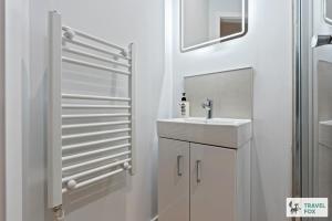 a white bathroom with a sink and a mirror at Anna's Central Stay in Nottingham