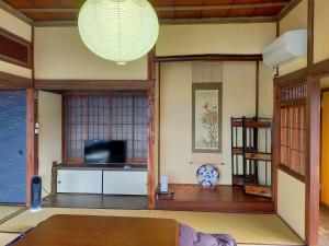 a living room with a television and a chandelier at R-house 5th - Vacation STAY 17834 in Numazu
