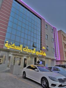 a white car parked in front of a building at Dar Hashim Hotel Suites - Al Sahafa in Riyadh