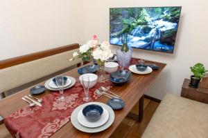 a dining room table with plates and glasses and flowers at J,Fine Miyagino 101 - Vacation STAY 27982v in Gora
